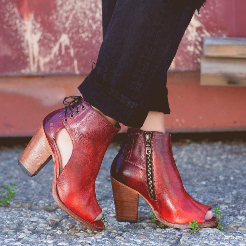 A woman wearing a pair of Bed Stu Angelique red leather boots.