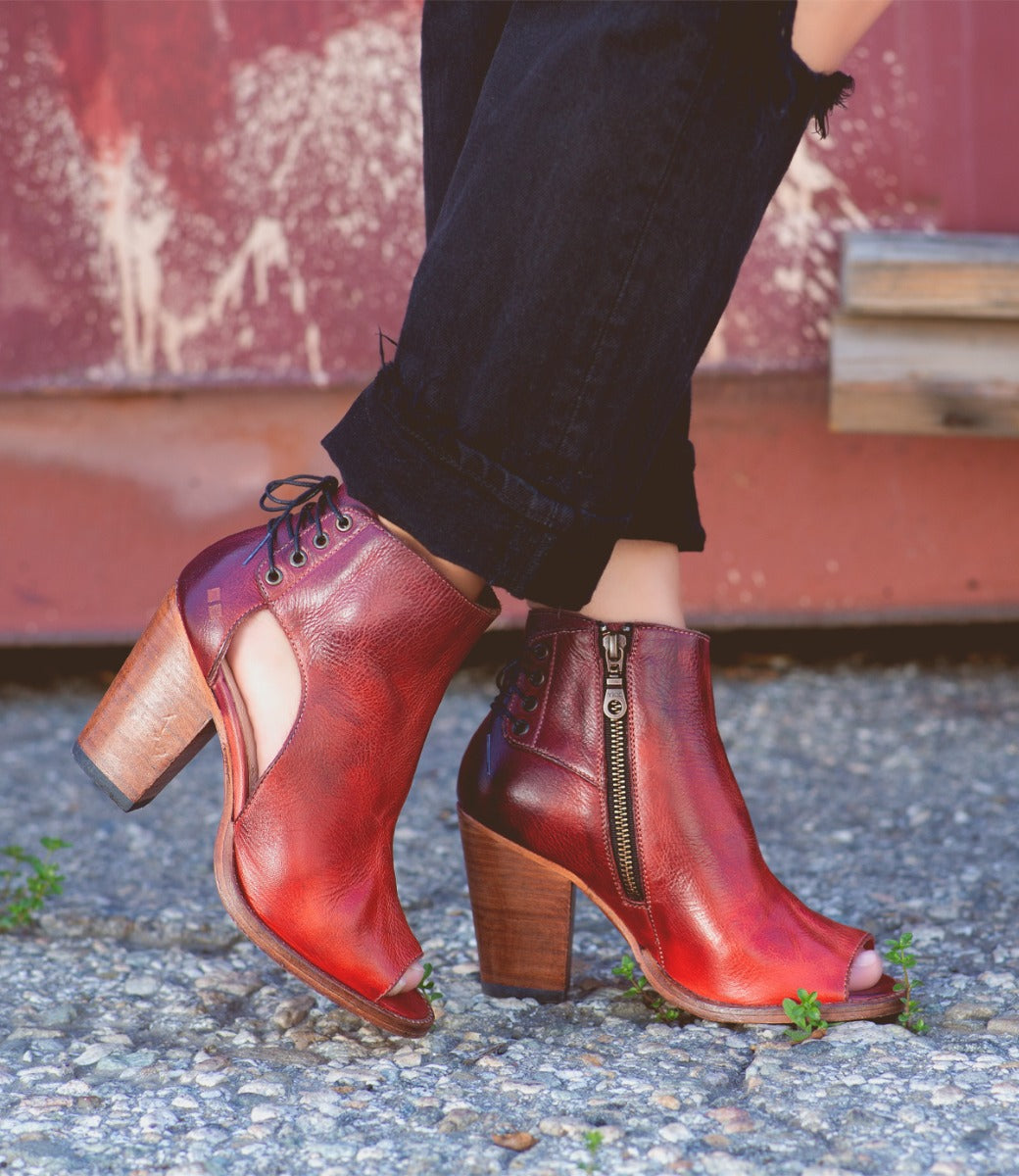 A woman wearing a pair of Bed Stu Angelique red leather boots.