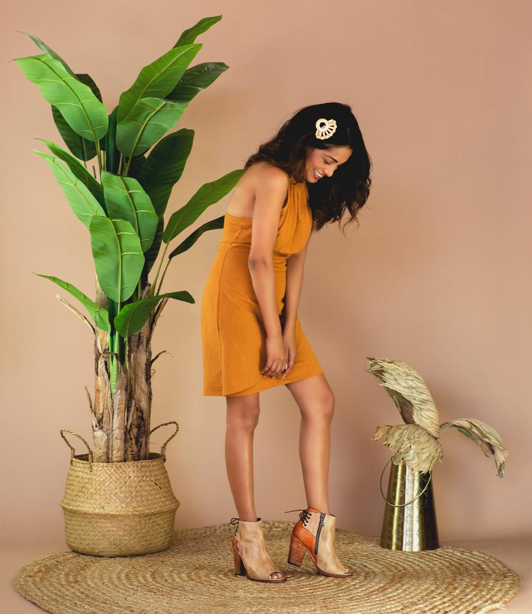 A woman in an Angelique boots by Bed Stu standing next to a potted plant.