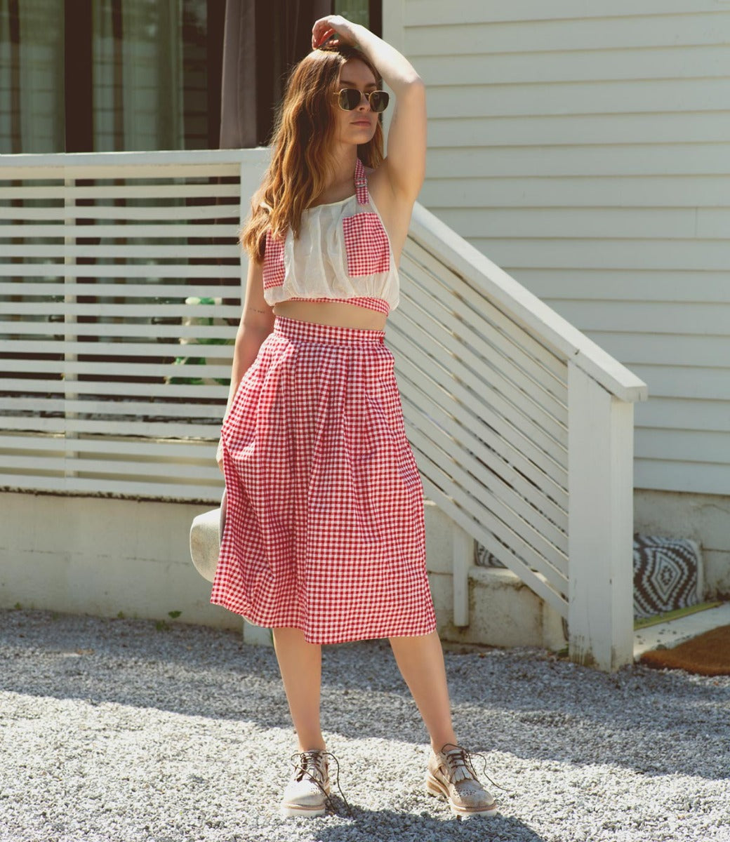 A woman in a red and white dress wearing a pair of Bed Stu Anise oxford shoes.