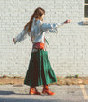 A woman wearing an Anne green dress and Bed Stu boots.