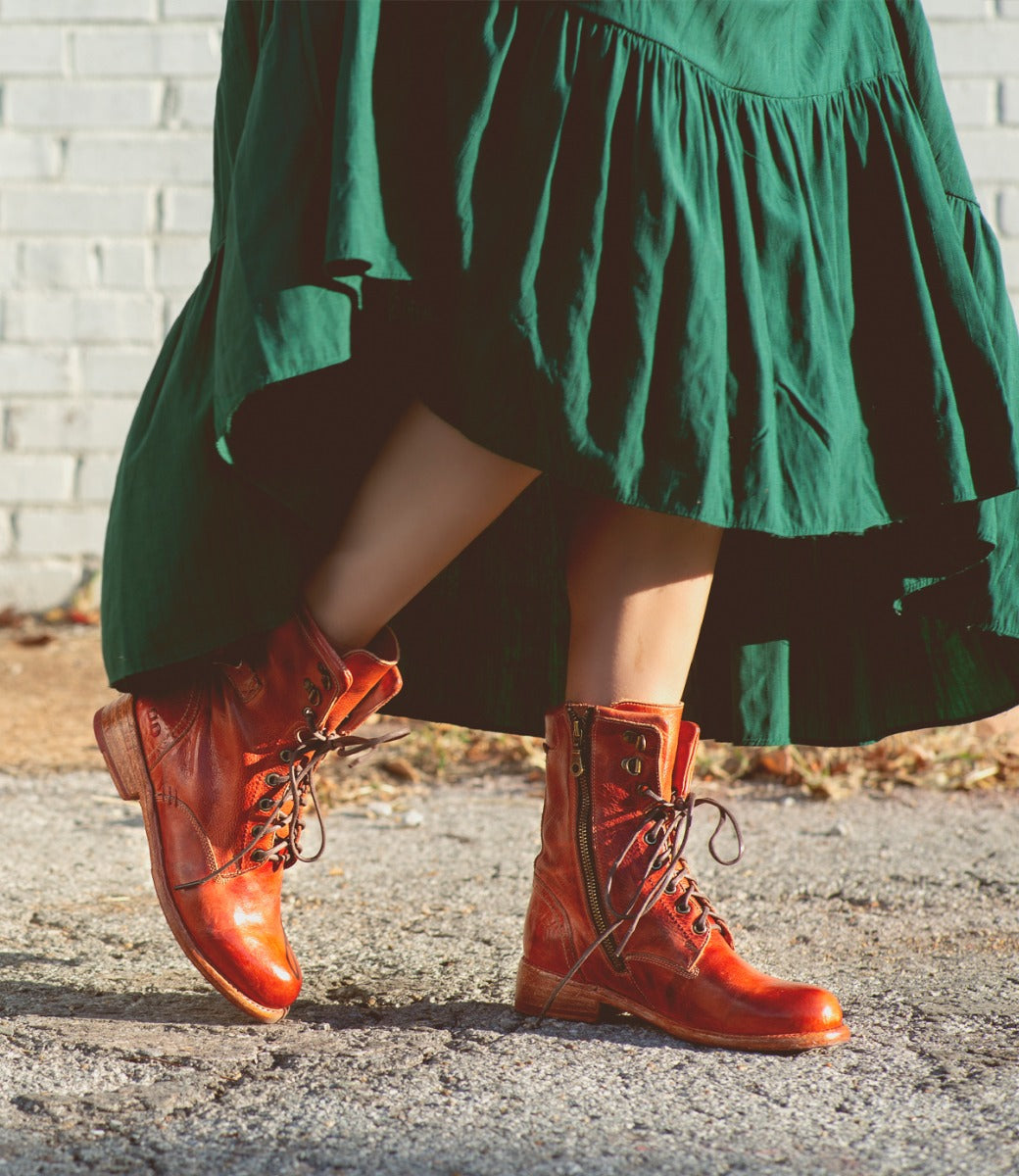 A woman wearing an Anne green dress and Bed Stu boots.