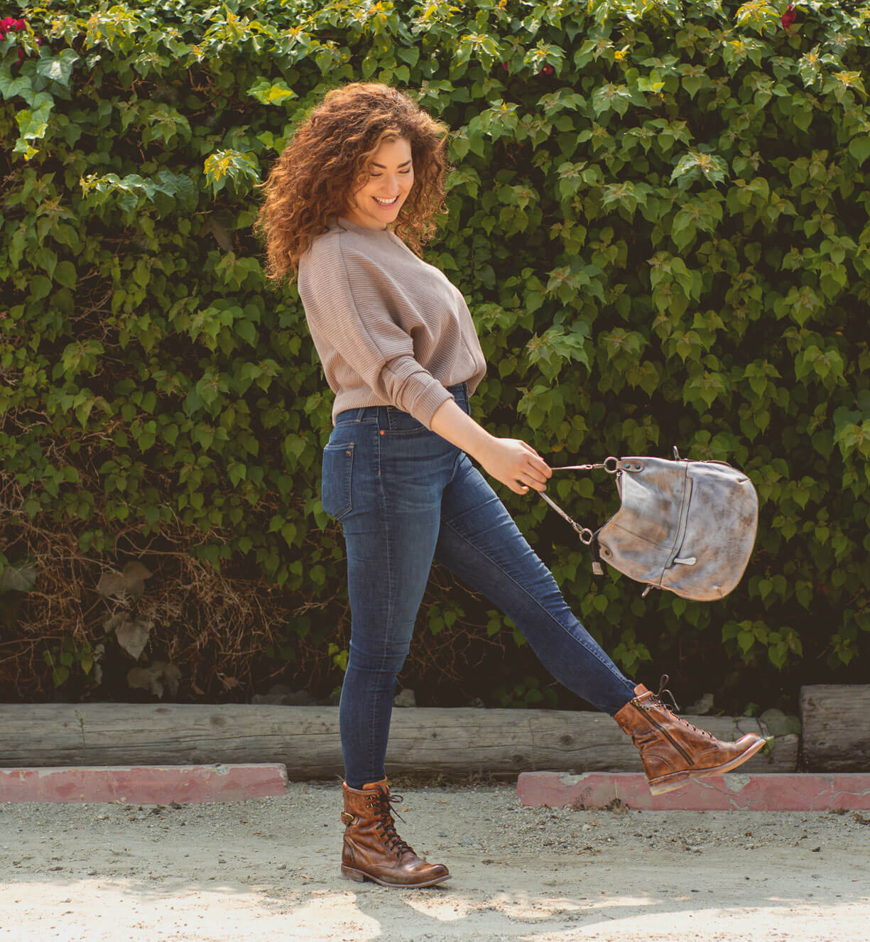 A woman wearing jeans and a brown pair of Bed Stu Anne boots.