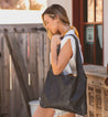 A woman wearing shorts and an Ariel leather tote bag by Bed Stu.