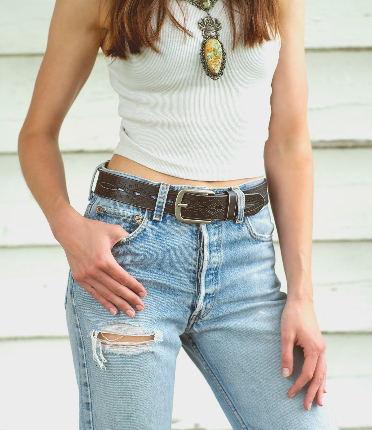 A woman in a white top and jeans is posing for a photo with the Arsenal by Bed Stu.