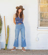A woman wearing Bed Stu hat and jeans standing next to a cactus.
