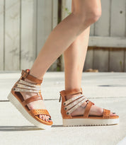 A woman wearing Bed Stu Artemia sandals on a sidewalk.