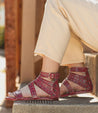 A woman wearing a pair of Bed Stu Artemis M red sandals.