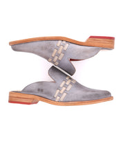 A pair of Asenet mule shoes by Bed Stu with a red sole.