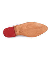 A pair of Bed Stu Asenet shoes with red soles on a white background.