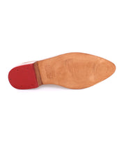 A pair of Bed Stu shoes with red soles on a white background.