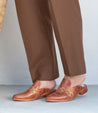 A woman wearing brown pants and a pair of Bed Stu Asenet shoes.