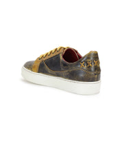 The Azeli by Bed Stu is a distressed brown low-profile sneaker with yellow laces, a durable white outsole, and decorative stitching on the heel.