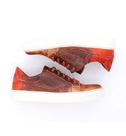A pair of brown and orange Azeli sneakers by Bed Stu on a white surface.