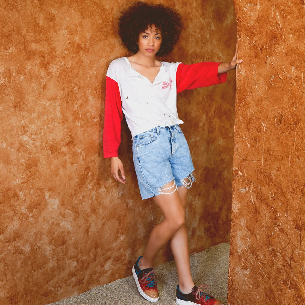 A woman in Azeli denim shorts leaning against a wall. (Bed Stu)