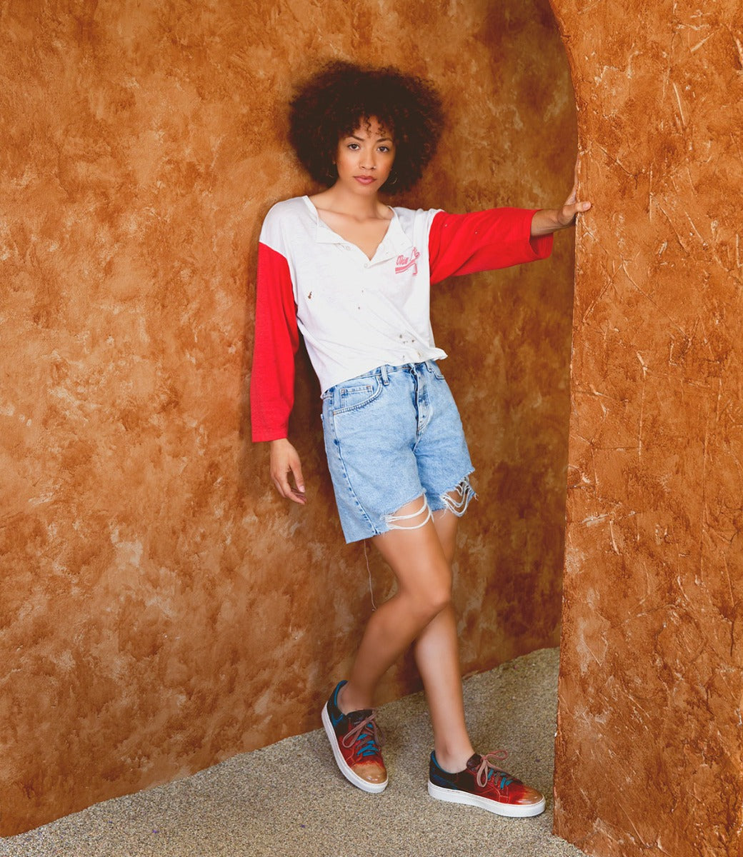 A woman in Azeli denim shorts leaning against a wall. (Bed Stu)