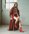 A woman in a red coat and Baila II boots from Bed Stu.