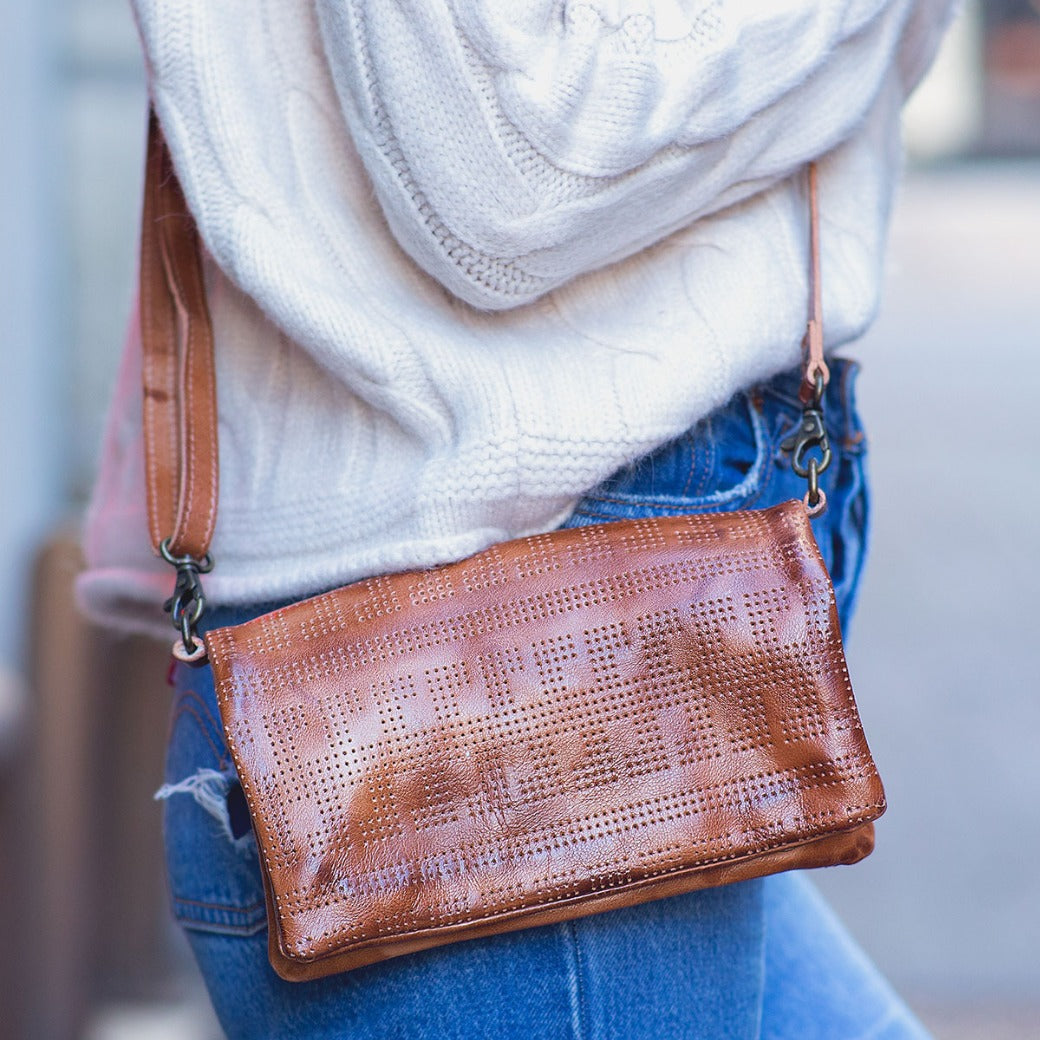 A woman wearing jeans and a Bed Stu Bayshore tan leather crossbody bag.