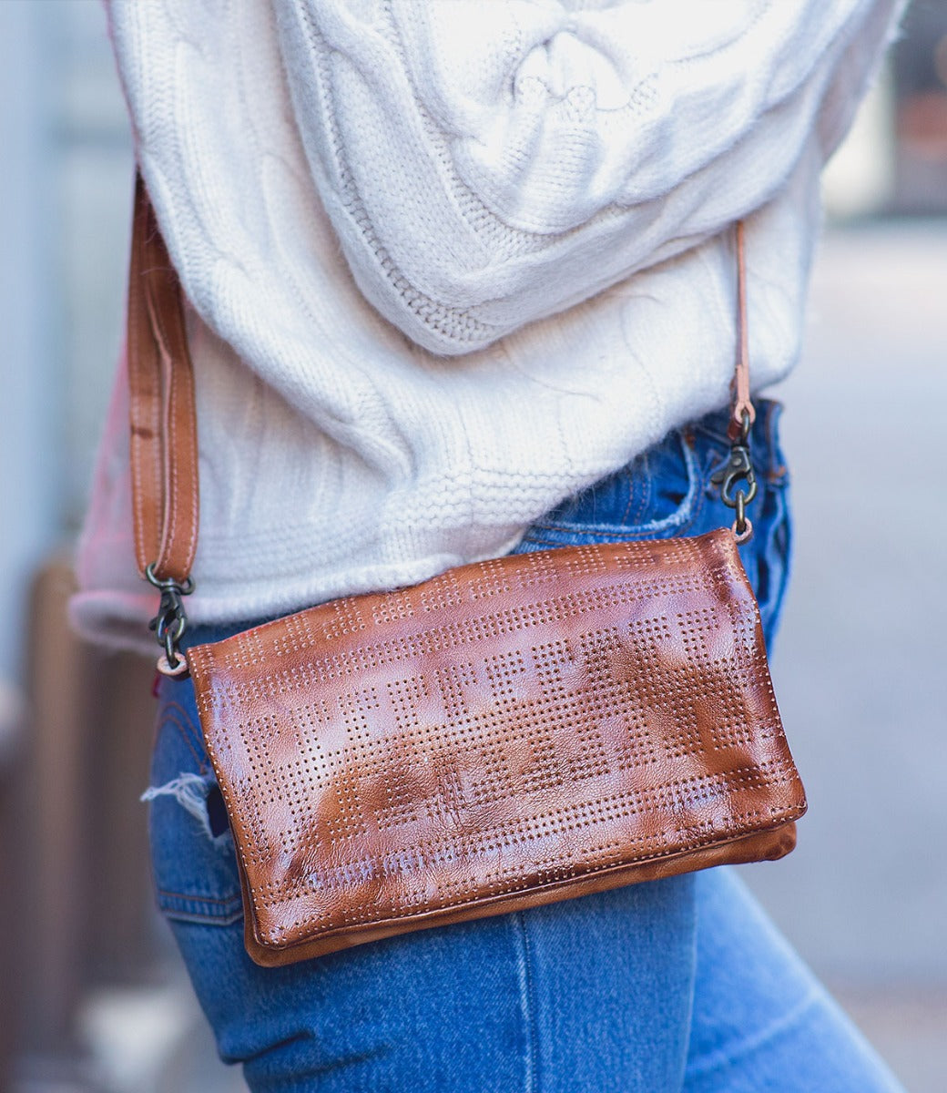 A woman wearing jeans and a Bed Stu Bayshore tan leather crossbody bag.