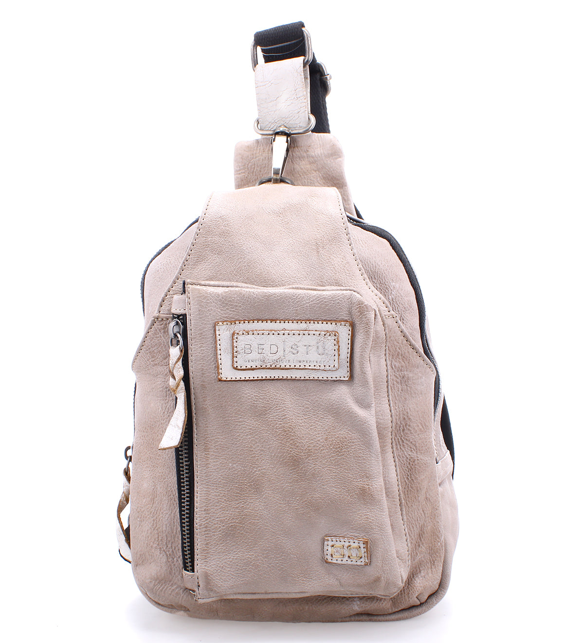 Beau by Bed|Stü is a beige leather sling bag featuring a front zippered pocket, stitched logo patch, top handle, and adjustable shoulder strap—perfect as a stylish and compact backpack for your everyday essentials.