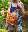 A woman wearing Beau overalls standing next to a river. Brand: Bed Stu.