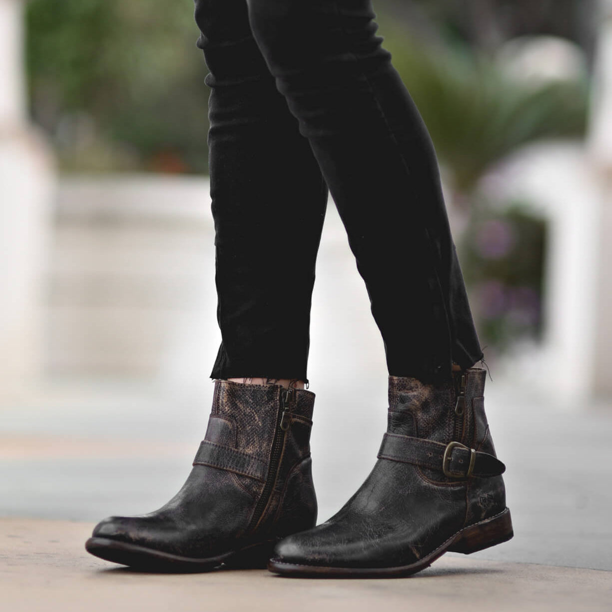 A woman wearing Becca black jeans and Bed Stu black boots.