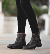 A woman wearing Becca black jeans and Bed Stu black boots.