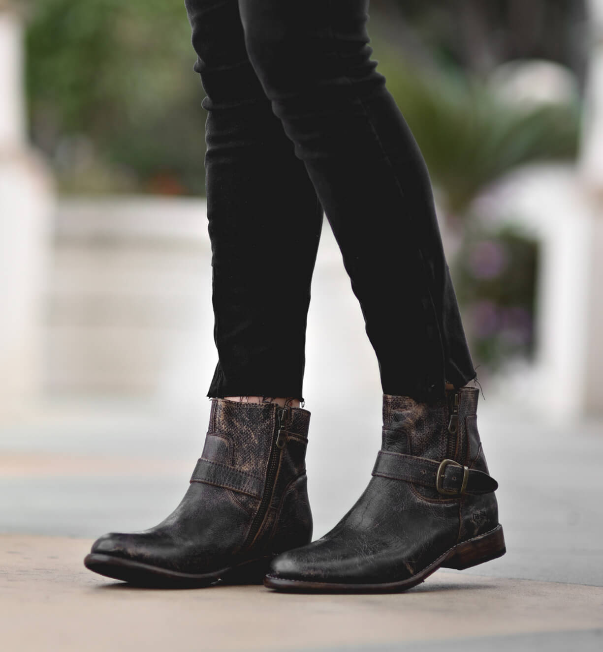 A woman wearing Becca black jeans and Bed Stu black boots.