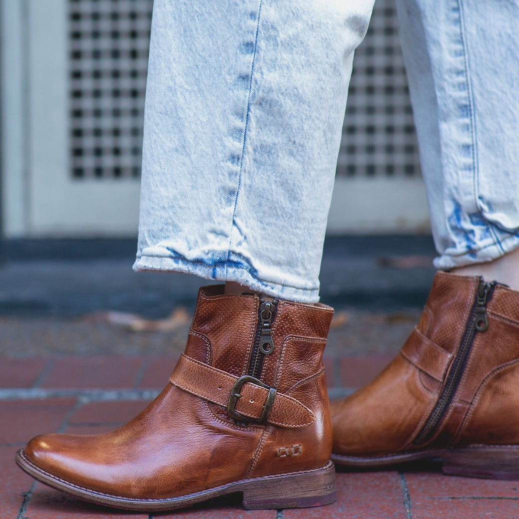 A woman wearing a pair of Bed Stu Becca tan leather boots.