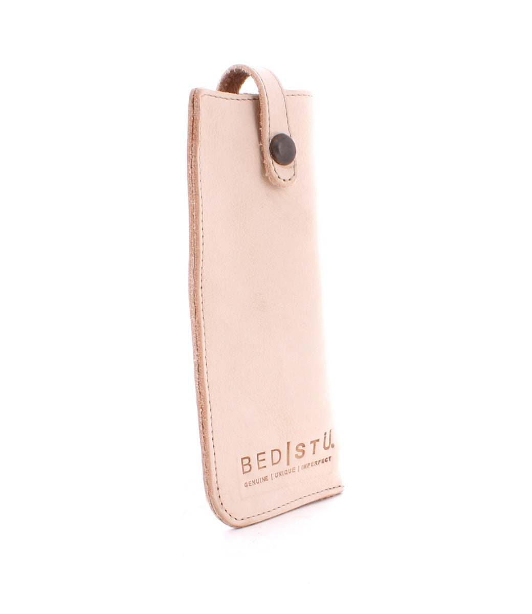 A beige leather case with the word Behold on it, by Bed Stu.