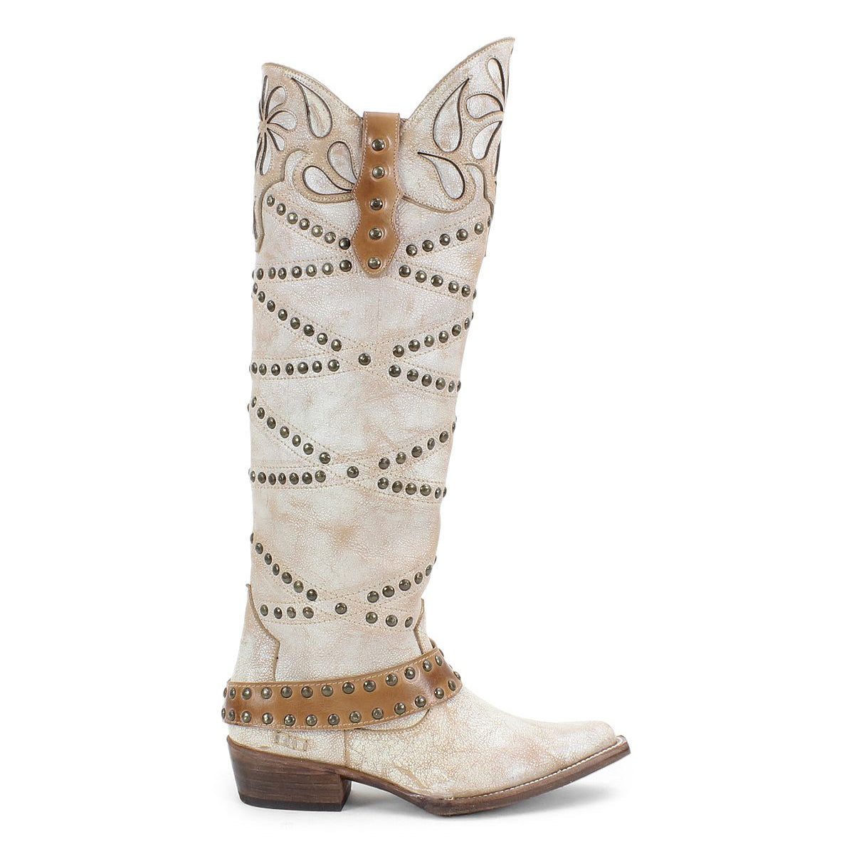 The Bed Stu "Betting" is a tall, white Western-style boot crafted from vegetable-tanned leather, decorated with brown harness straps and studs. It includes a patterned upper and a low heel, offering rustic elegance to any outfit.