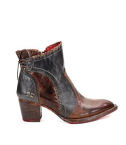Introducing the Bia boot by Bed Stu: A handcrafted brown leather bootie with a textured black upper, decorative stitching, and a medium stacked wooden heel. This comfortable boot features a striking red lining and elegant lace-up detail at the back.