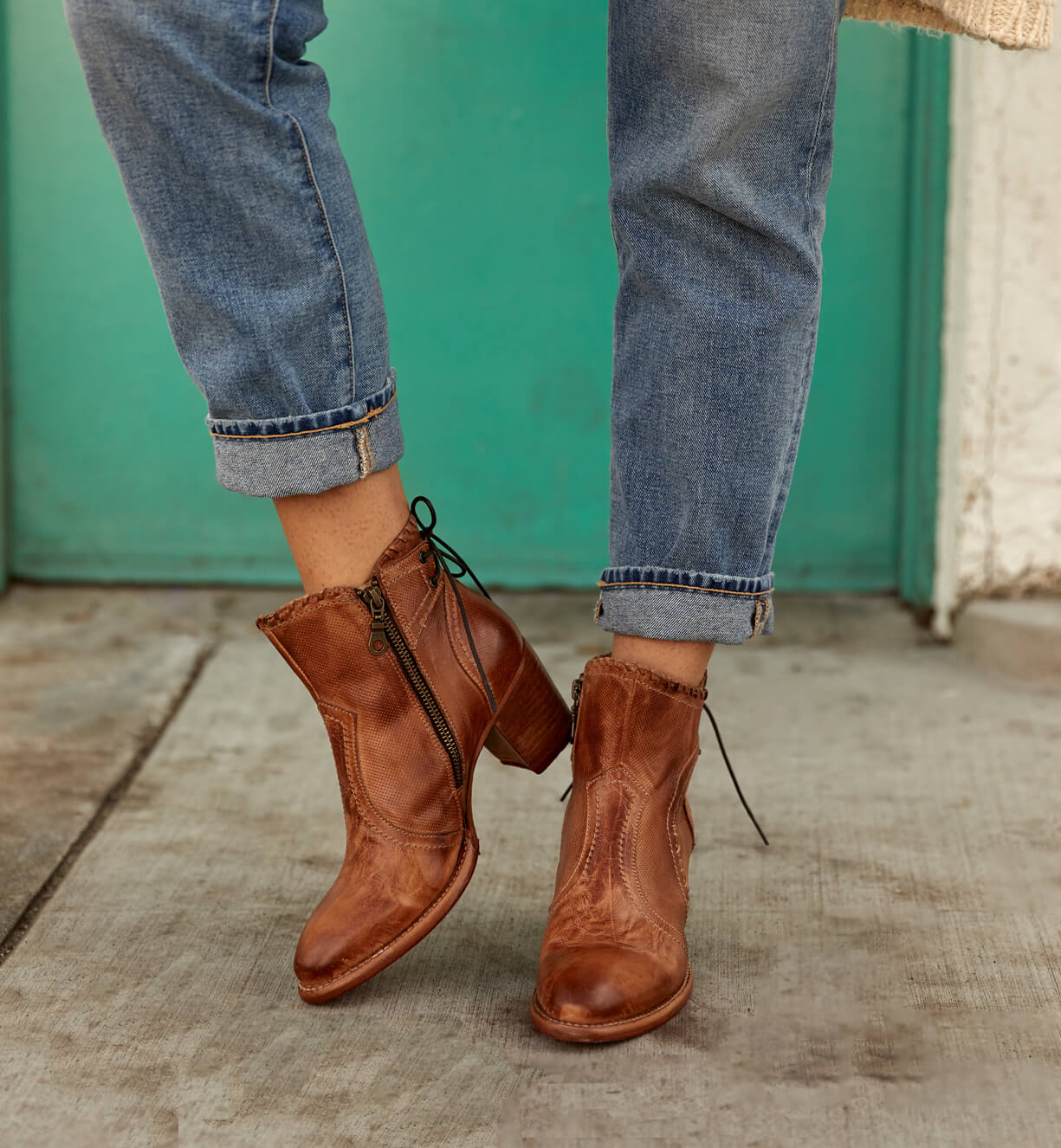 A woman wearing a pair of Bed Stu Bia boots and jeans.