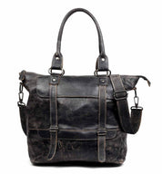 The Big Fork by Bed Stu is a black leather tote bag featuring two handles, front straps, and an adjustable crossbody strap. Meticulously crafted from full grain leather, the bag boasts a weathered look complemented by metal buckle accents.
