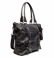 Introducing the Big Fork by Bed Stu - a spacious black full grain leather handbag equipped with two top handles and an adjustable crossbody strap. This stylish bag features multiple buckles and a front flap pocket, skillfully merging elegance with practicality.
