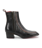 The Bitsy by Bed Stu is a black, hand-finished leather ankle boot featuring a low stacked wooden heel, side zipper, brown piping, back pull tab, and a slightly pointed toe for extra style.