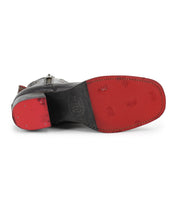 A close-up view of the Bed Stu Bitsy men's ankle boot underside, featuring a red sole, hand-finished leather, and visible edge stitching.
