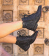 An enduring woman's legs in lace-up black leather Bed Stu Bonnie combat ankle boots.