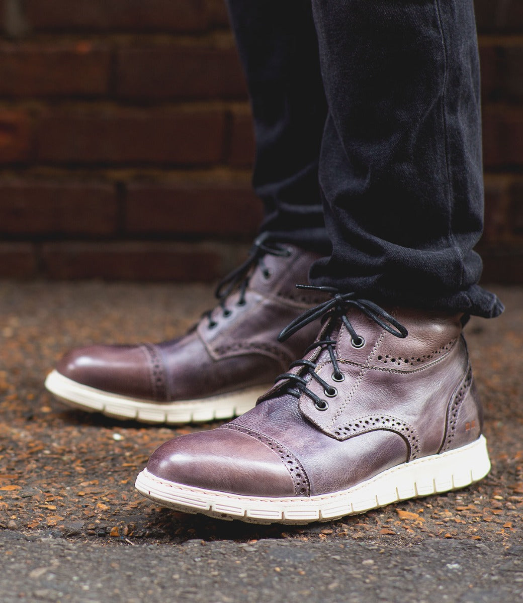 A man wearing a pair of Bed Stu Bowery II brown leather boots.