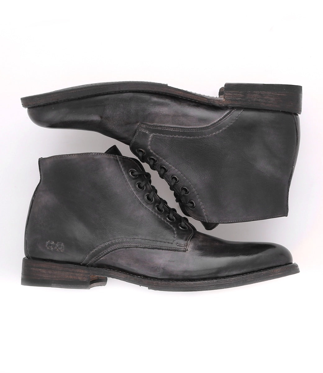 A pair of Bed Stu black leather boots on a white background.