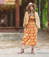 A woman in a dress standing in front of a building, wearing Brianna boots by Bed Stu.