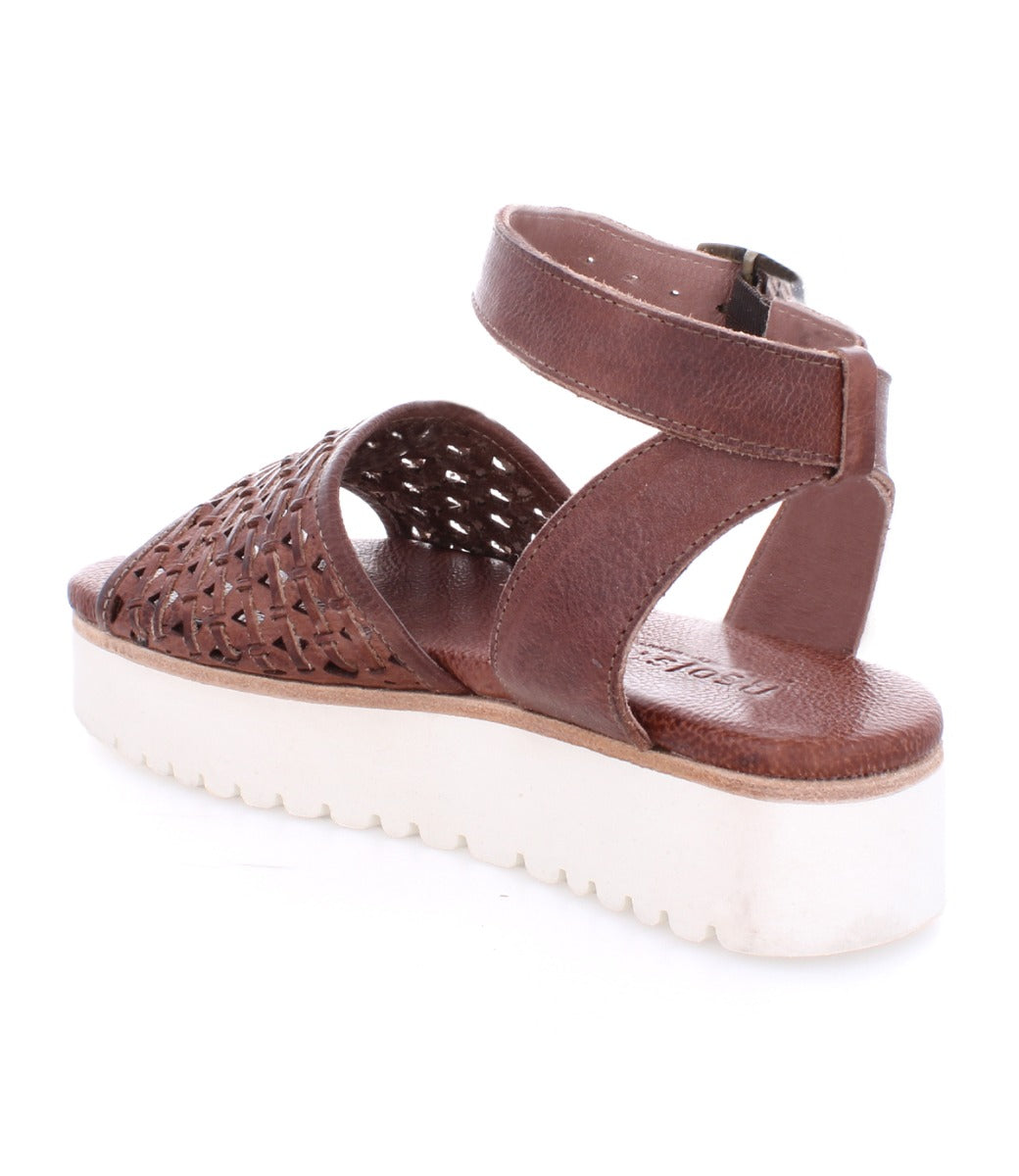 A women's brown Brisa sandal with woven straps and a white sole by Bed Stu.