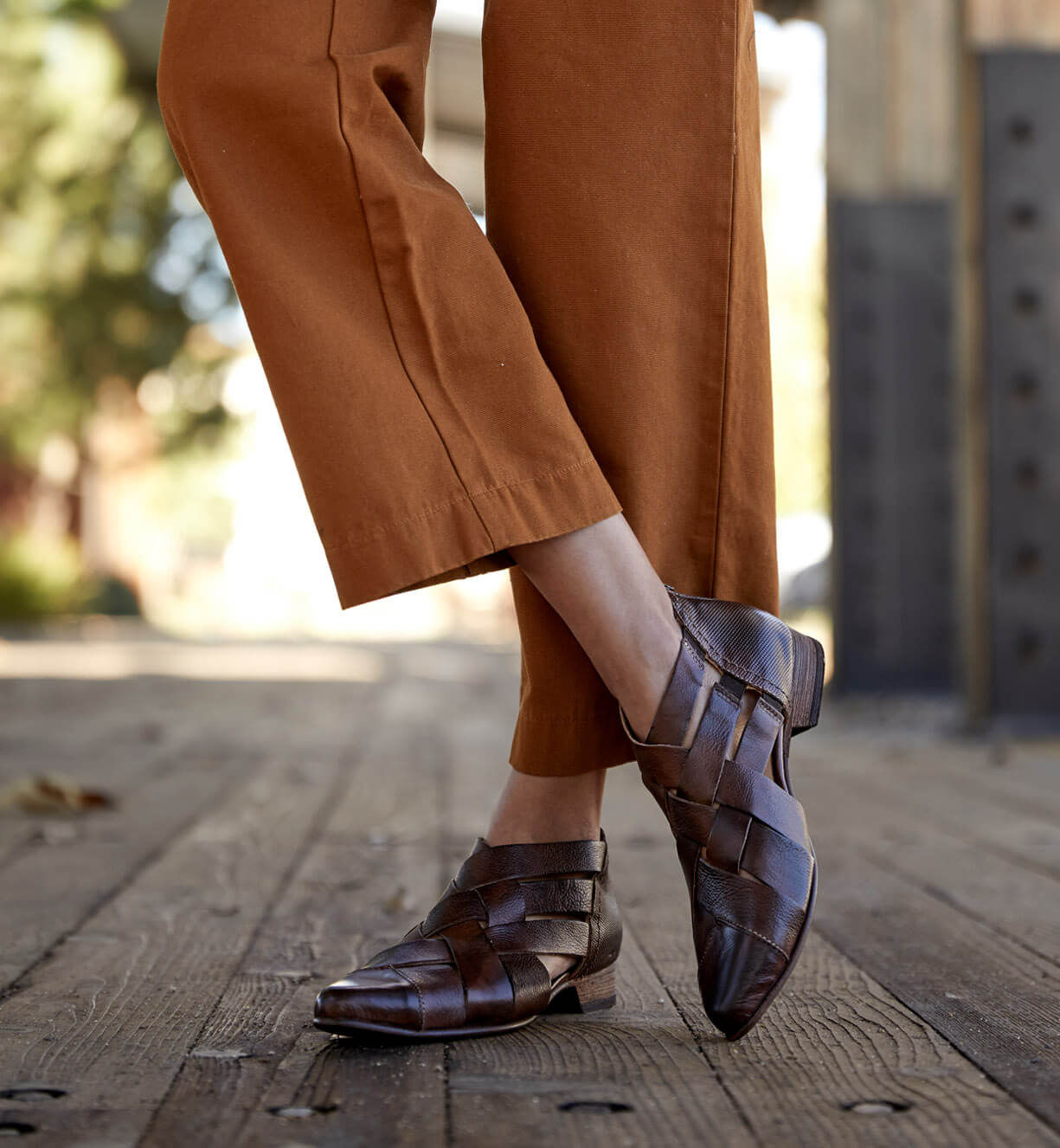 A woman wearing brown Brittany pants and Bed Stu shoes.
