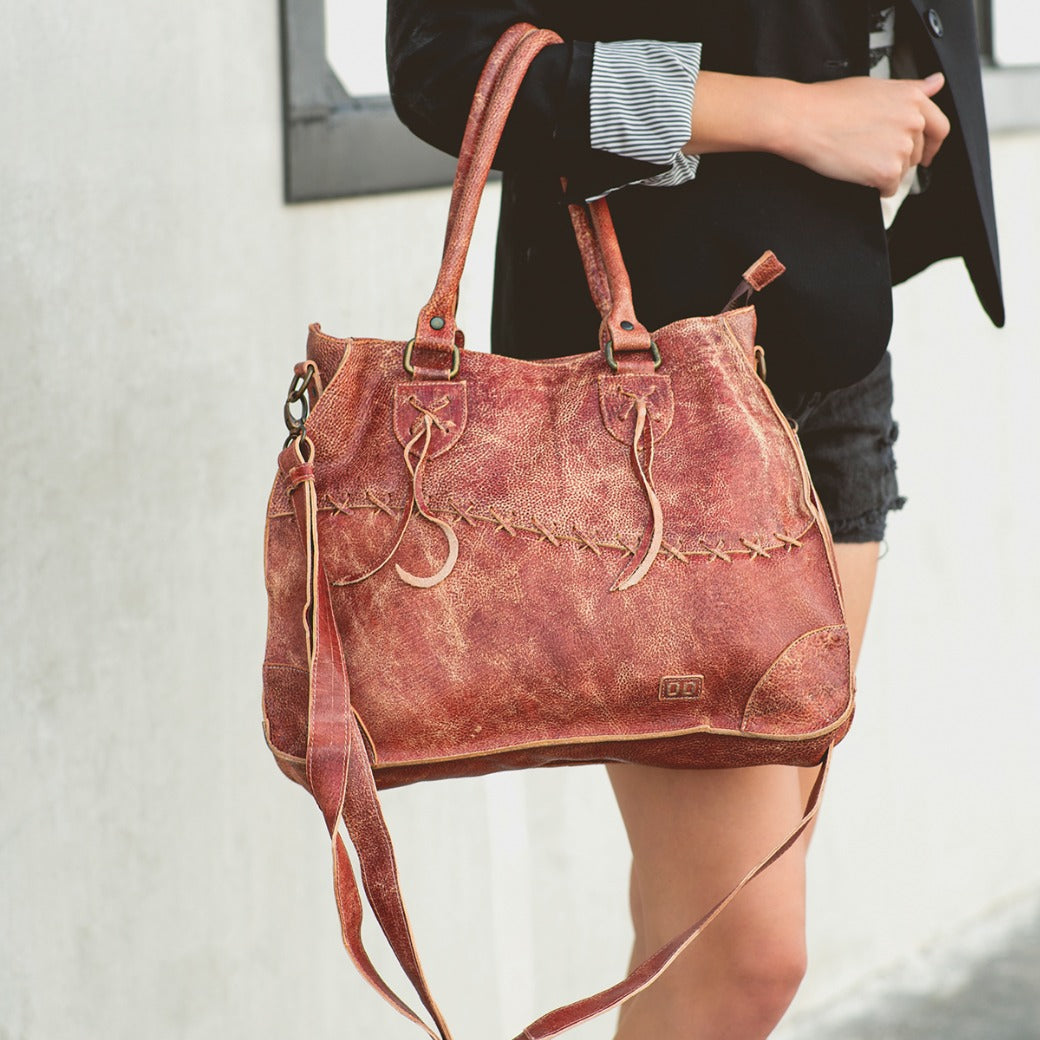 A woman carrying a burgundy Bed Stu Bruna leather bag.
