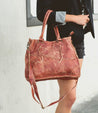 A woman carrying a burgundy Bed Stu Bruna leather bag.