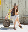 A woman carrying a black and white Bed Stu Bruna pure leather bag.