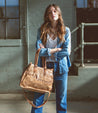 A woman wearing jeans and a Bed Stu Bruna bag.
