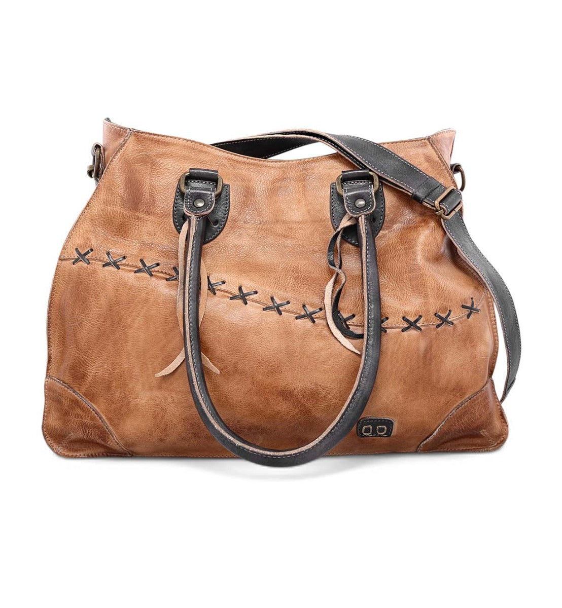 A woman carrying a tan Bed Stu Bruna leather bag with black straps.