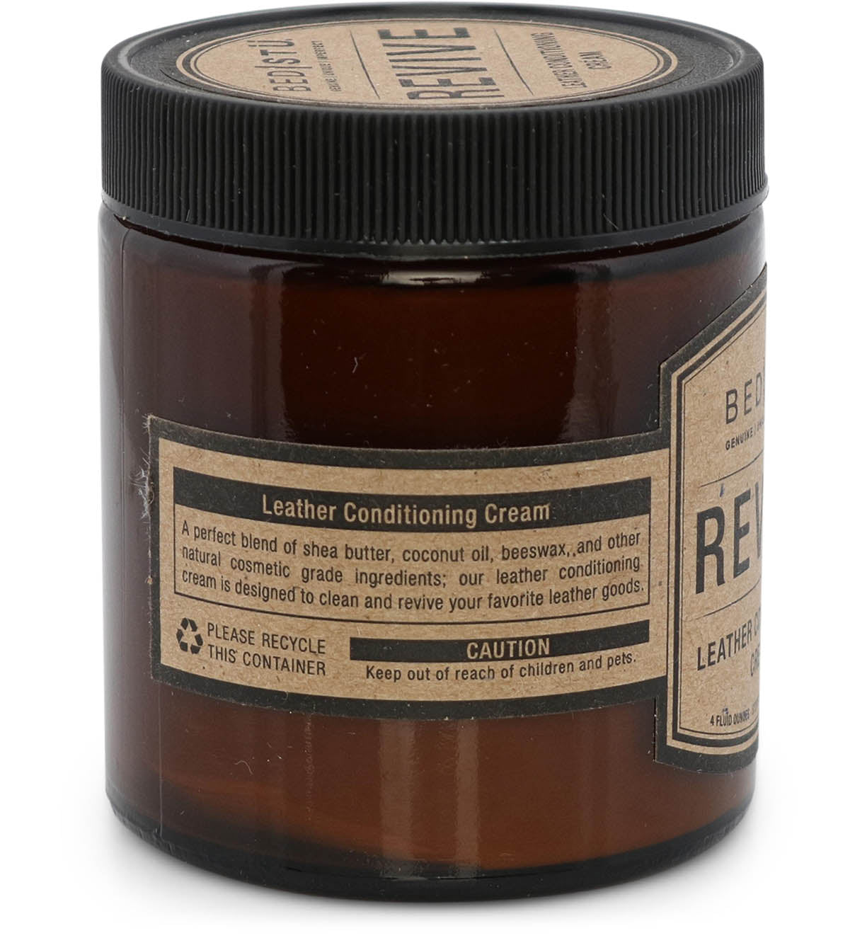 A jar of Bed|Stü Revive Leather Care Package leather conditioning cream with labels detailing a blend of shea butter, coconut oil, and beeswax. Instructions and warnings are visible.