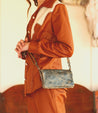 A woman wearing a Bed Stu Cadence brown leather clutch.